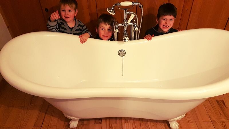 Three little boys preparing to have a bath together to reduce water waste